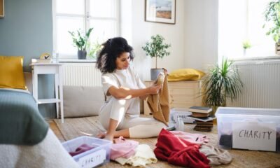 Young woman sorting wardrobe indoors at home, charity donation concept