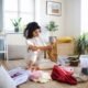 Young woman sorting wardrobe indoors at home, charity donation concept